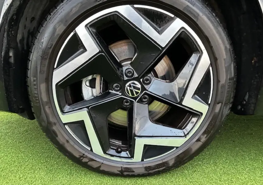 Gros plan sur la jante alliage 19 pouces noire et argentée du Volkswagen Tiguan III gris clair 2024.