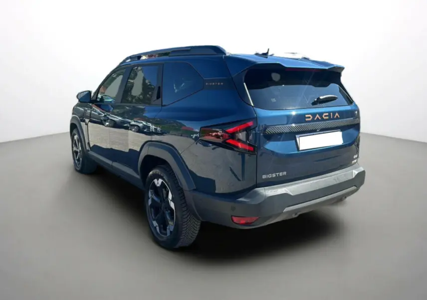 Vue 3/4 arrière droite du Dacia Bigster 2025 bleu indigo avec logo et feux arrière au design anguleux.