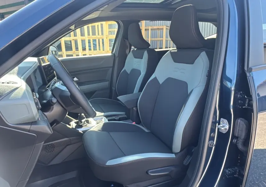 Intérieur du Dacia Bigster TCE 130 4x4 Extreme Plus 2025, vue côté conducteur, sièges bicolores noirs et gris.