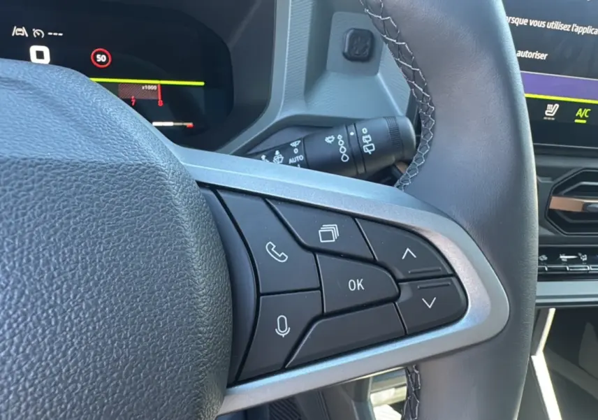 Gros plan sur les commandes au volant du Dacia Bigster 2025, finition TCE 130 4X4 Extreme Plus, intérieur moderne.