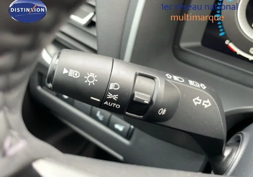 Gros plan sur la manette des feux et clignotants du Nissan Qashqai 1.5 E-POWER gris, intérieur côté gauche.
