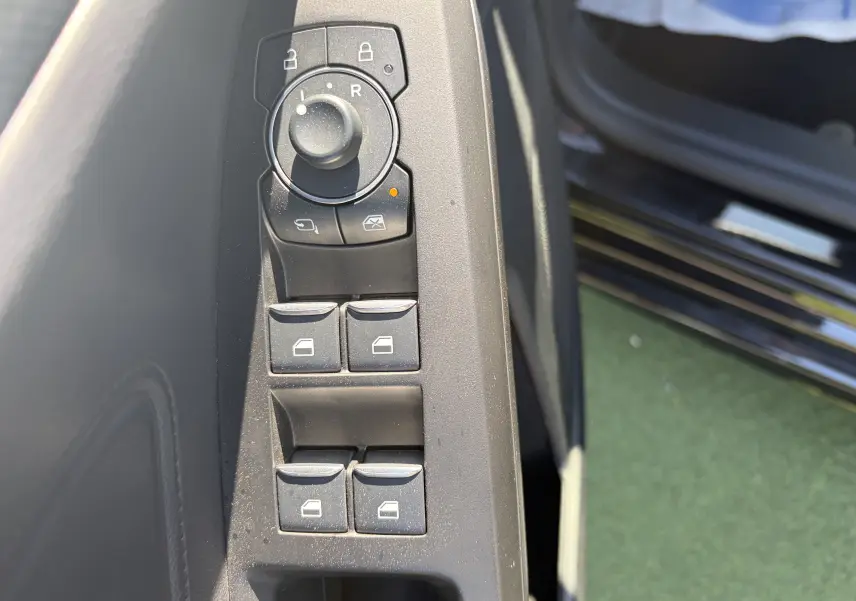 Commande des vitres et réglage des rétroviseurs côté conducteur sur porte noire Agate d'une Ford Focus IV ST-Line X.