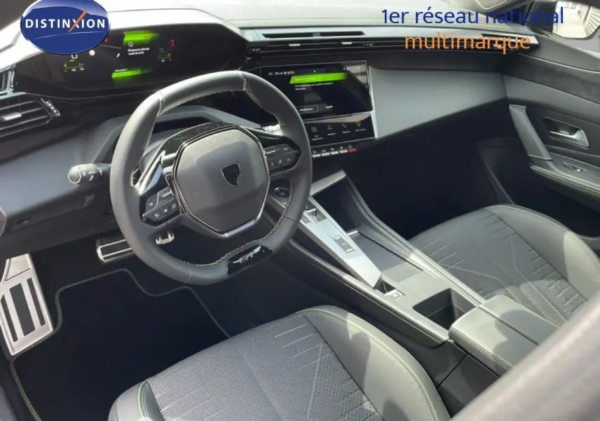 Vue intérieure de la Peugeot 308 1.2 Hybrid 145ch GT, montrant le volant compact et la console centrale moderne en gris artense.