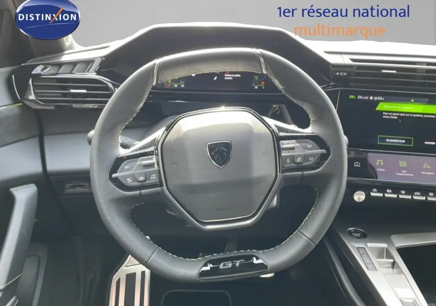 Vue intérieure centrée sur le volant GT de la Peugeot 308 gris Artense, avec tableau de bord et écran tactile visibles.