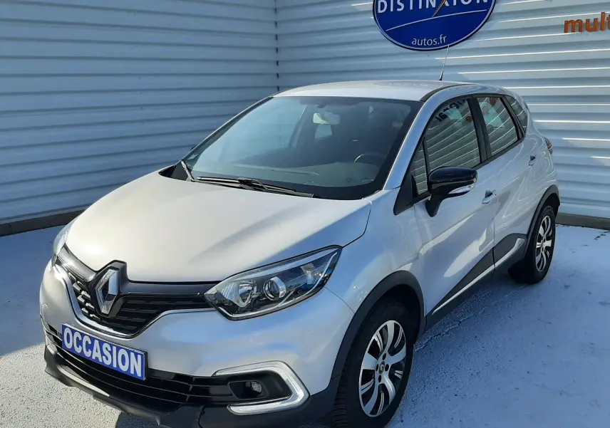 Renault Captur gris platine métal en 3/4 avant droit, avec jantes alliage et calandre noire distinctive.