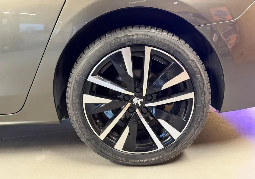 Gros plan sur la jante alu noire et argentée côté arrière droit d'une Peugeot 508 gris métallisé.