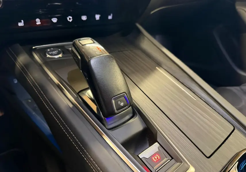 Gros plan sur la console centrale cuir et bois avec levier de vitesses automatique et bouton frein de parking Peugeot 508 gris.