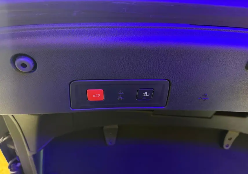Gros plan sur les boutons de fermeture et de verrouillage du hayon d'une Peugeot 508 gris, éclairage bleu.