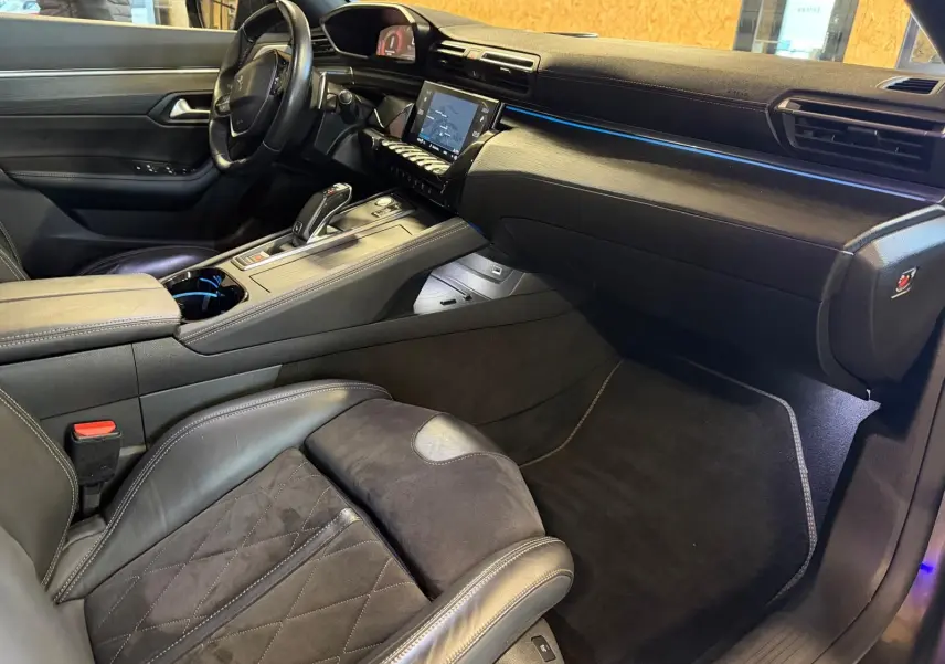 Vue intérieure côté passager avant du Peugeot 508 gris, mettant en valeur la sellerie cuir et Alcantara ainsi que la console centrale moderne.