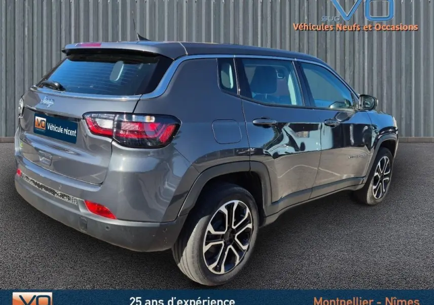 Jeep Compass gris 3/4 arrière droit, jantes alliage 18 pouces, feux arrière LED et vitres teintées.