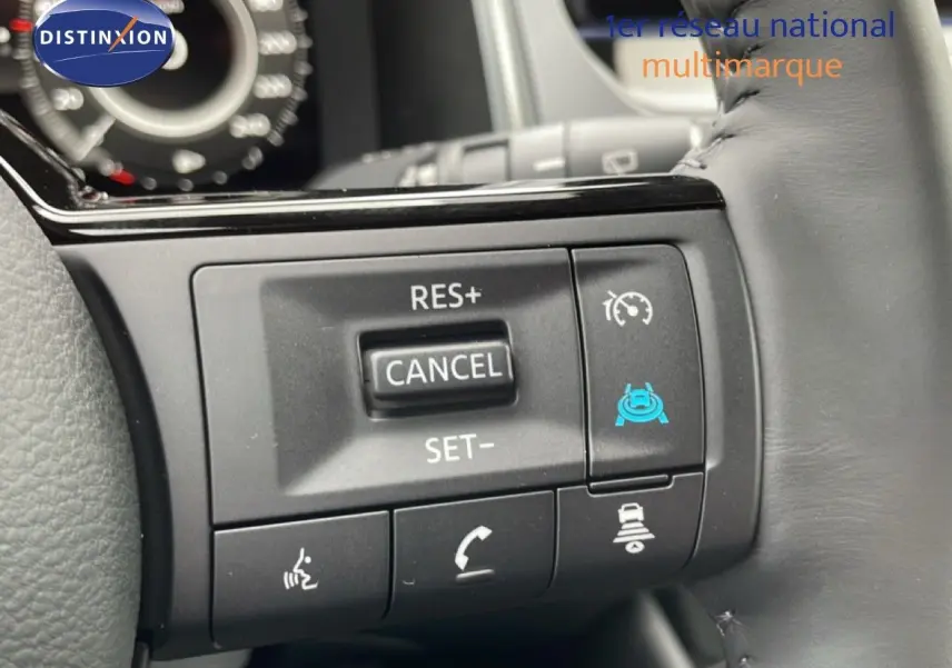 Gros plan sur les commandes au volant du Nissan Qashqai gris, avec régulateur de vitesse et aides à la conduite.