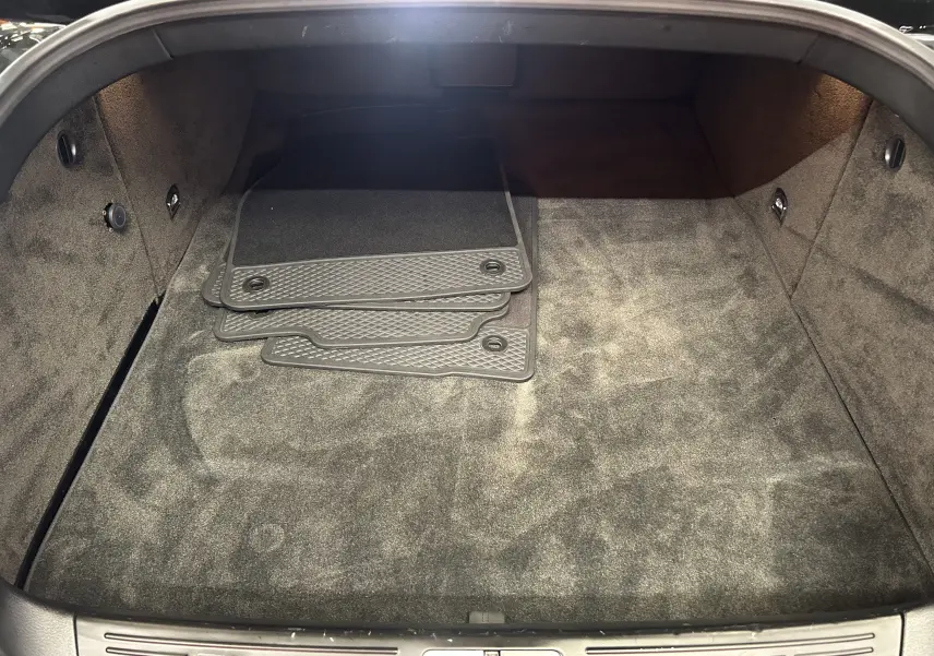 Vue intérieure du coffre spacieux et propre de la Bentley Continental Flying Spur 2006, avec tapis de sol gris empilés.