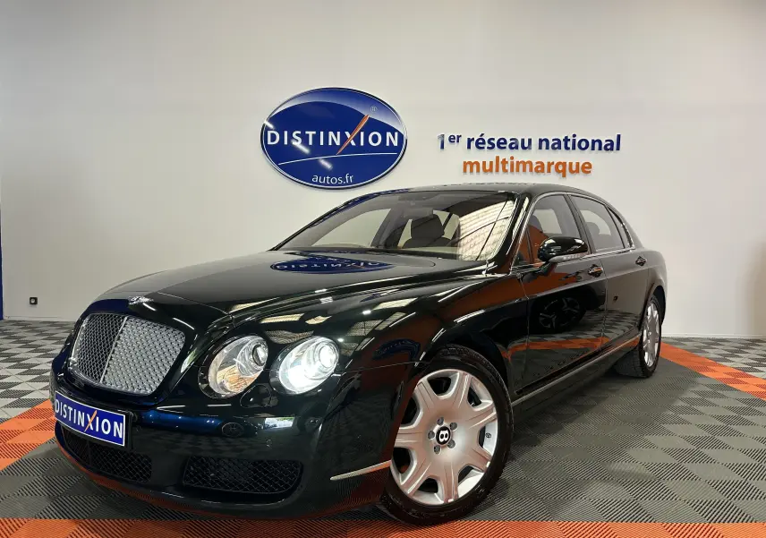 Vue 3/4 avant droite d'une Bentley Continental Flying Spur vert foncé avec calandre chromée et jantes argentées.