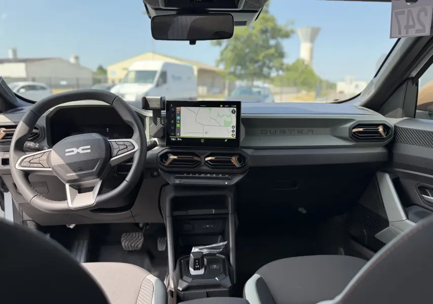 Vue intérieure avant du Dacia Duster Hybrid 155 Extreme 2026, tableau de bord moderne avec écran tactile et volant multifonction.