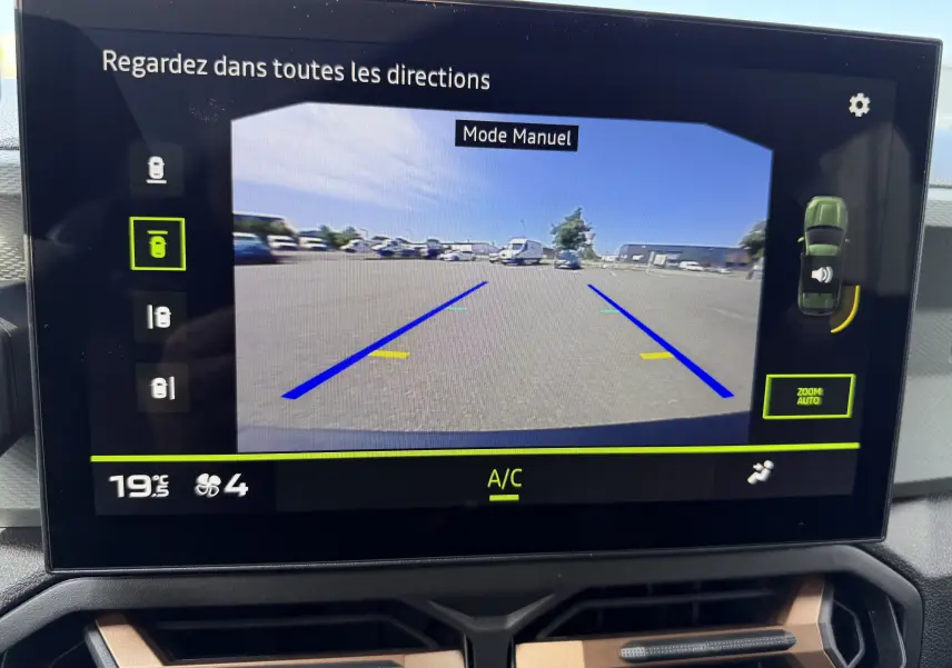 Écran central du Dacia Duster Hybrid 155 Extreme montrant la caméra de recul avec lignes de guidage en bleu et jaune.