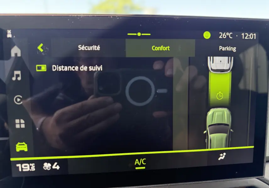 Écran tactile intérieur du Dacia Duster Hybrid 155 Extreme montrant les réglages de sécurité et confort avec vue parking en affichage numérique.