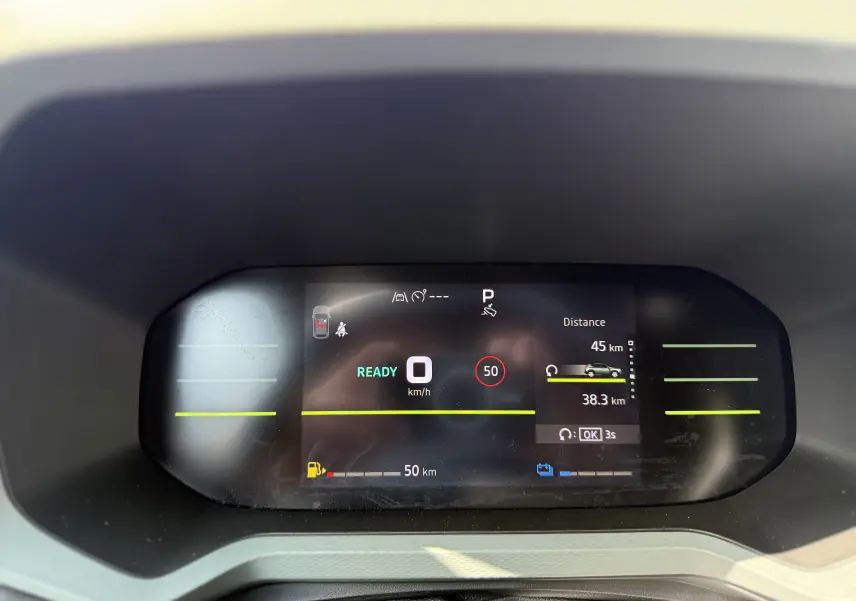 Affichage numérique du tableau de bord du Dacia Duster Hybrid 155 Extreme montrant la vitesse à 0 km/h et l'autonomie restante.