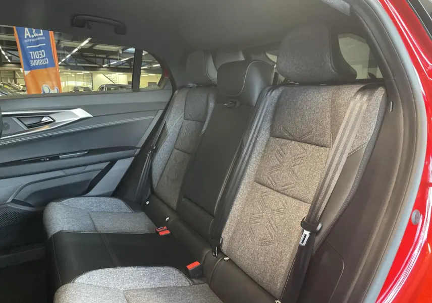 Vue intérieure côté droit sur la banquette arrière bi-matière gris clair et noir du Renault Rafale rouge 2025.