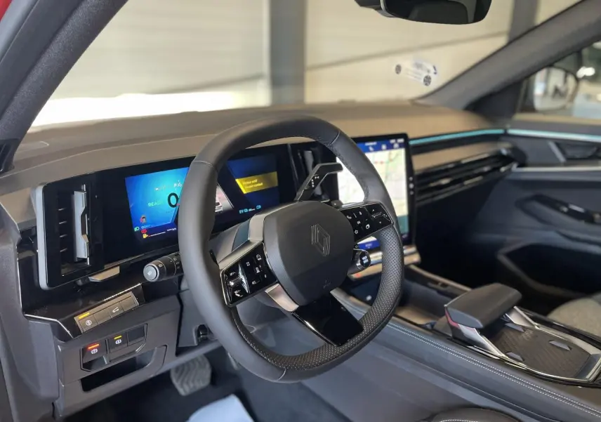Intérieur Renault Rafale 2025 vu côté conducteur, volant cuir noir, tableau de bord numérique et écran tactile central.