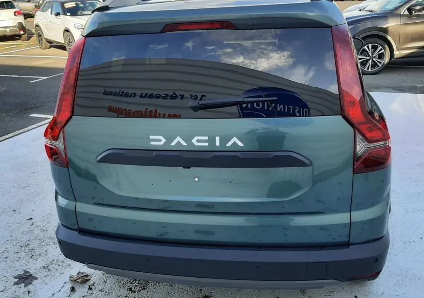Vue arrière d'un Dacia Jogger vert cèdre métal 2025 avec hayon teinté et feux arrière en forme de L.