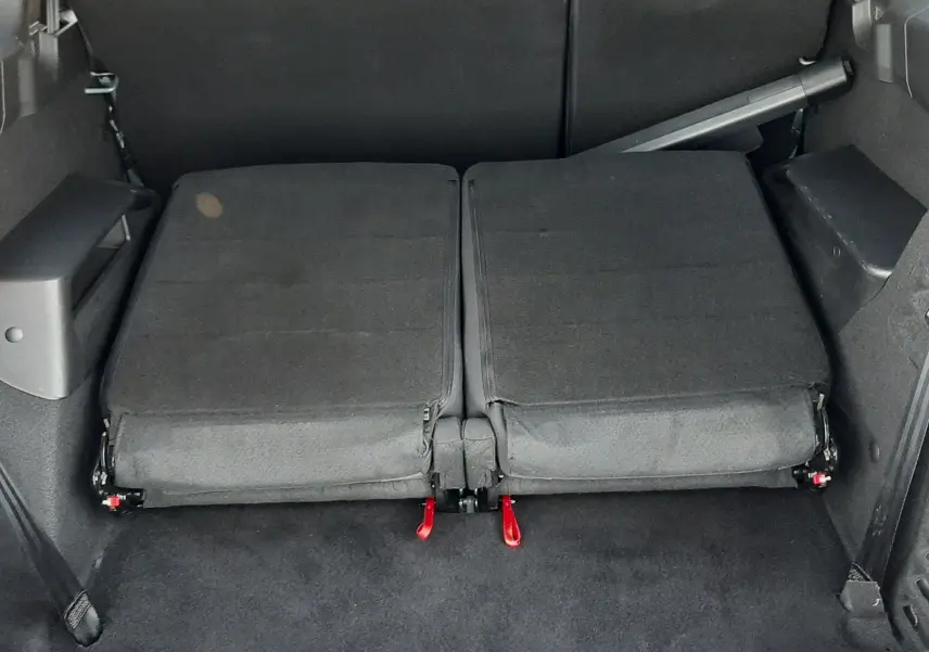 Vue arrière du coffre du Dacia Jogger 2025 avec sièges rabattus en tissu noir, offrant un espace de chargement plat.