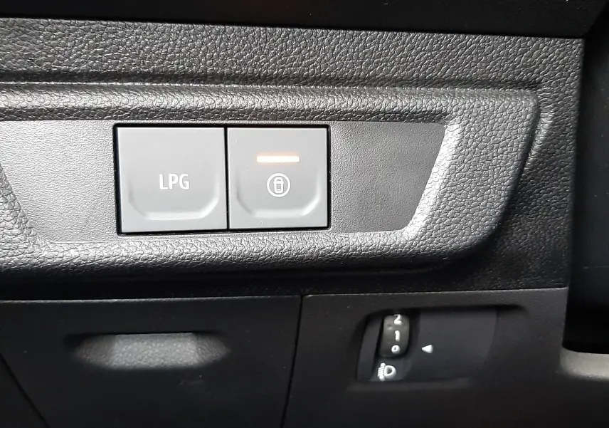 Gros plan sur les boutons de commande LPG et verrouillage, tableau de bord noir du Dacia Jogger 2025 côté gauche.