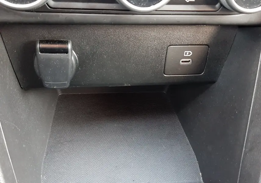 Détail de la console centrale du Dacia Jogger 2025 montrant une prise USB-C et un port 12V sous les commandes de climatisation.
