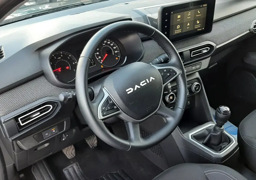 Vue intérieure du tableau de bord et volant DACIA Jogger 2025, finition noire avec écran tactile et boîte manuelle.