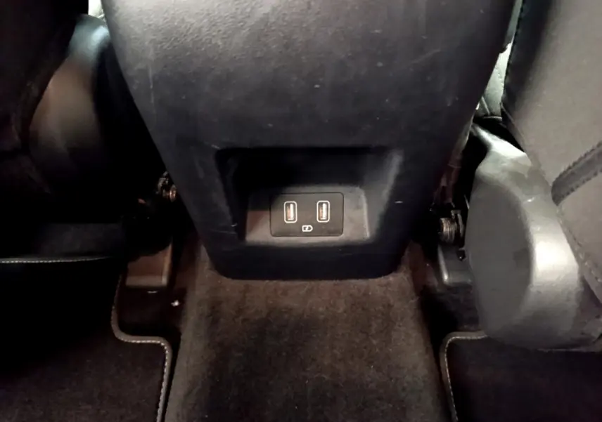 Vue intérieure du Hyundai Tucson 1.6 Hybrid 230 Creative 2022, prise du sol montrant la prise USB double à l'arrière de la console centrale.