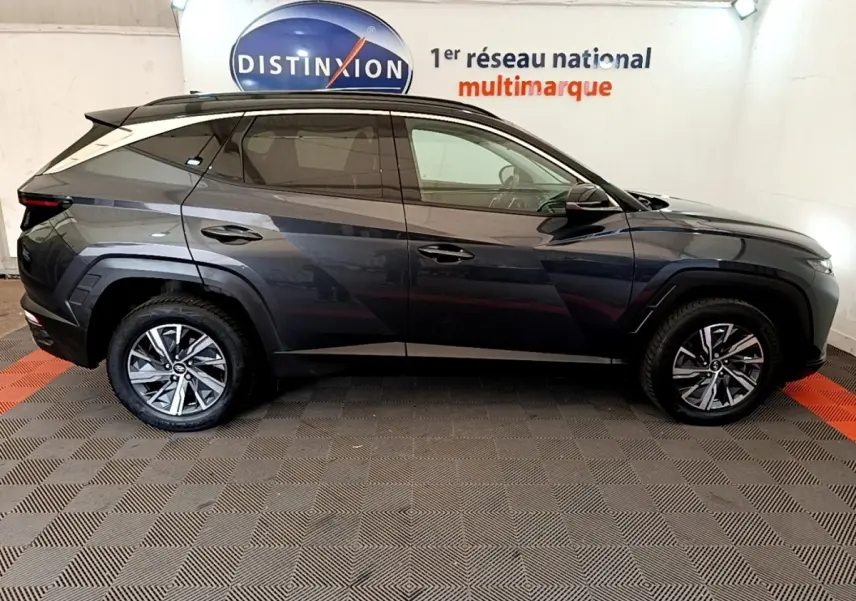 Profil droit du Hyundai Tucson 1.6 Hybrid 230 Creative gris foncé, avec jantes alliage et vitres teintées.
