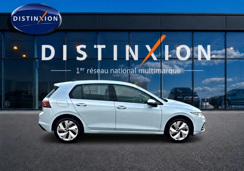 Volkswagen Golf 2026 bleu glacier vue de profil côté gauche devant showroom Distinxion.