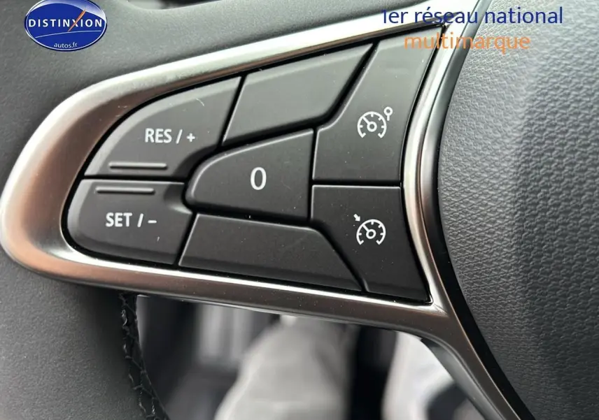 Gros plan sur les commandes de régulateur de vitesse au volant cuir d'une Renault Clio V noire étoilé.