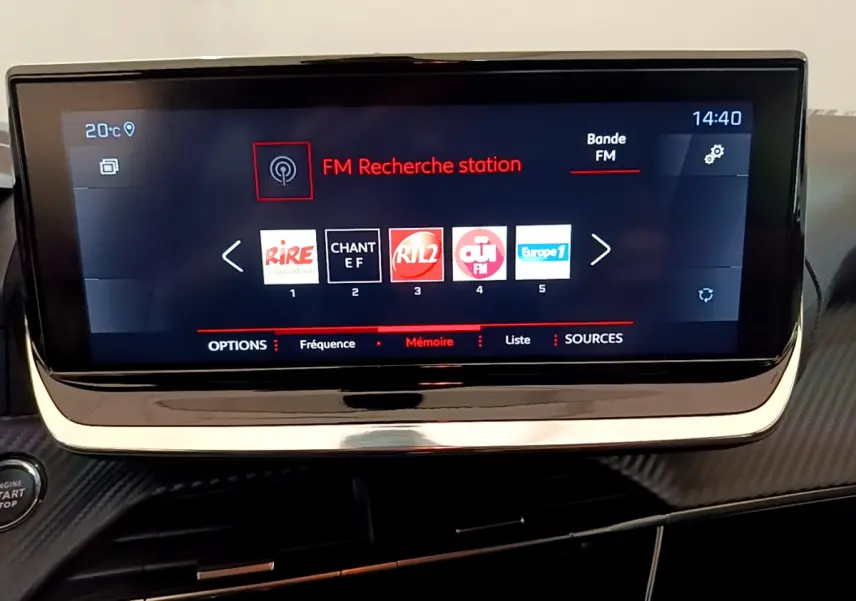 Écran tactile central de 7 pouces affichant la radio FM dans l'habitacle d'une Peugeot 208 blanche de 2020.