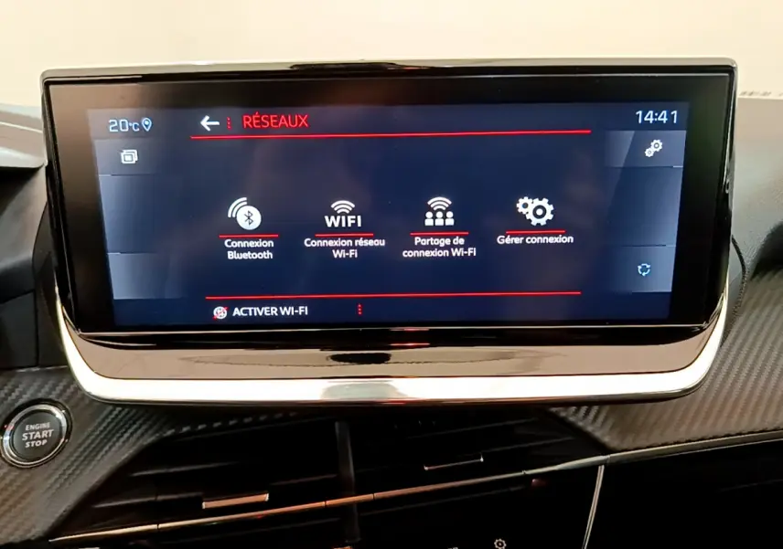 Écran tactile central affichant les options de connexion Wi-Fi et Bluetooth dans le tableau de bord noir du Peugeot 208 blanc.