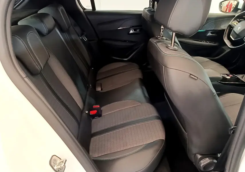 Vue intérieure côté gauche sur la banquette arrière et siège avant gris anthracite d'une Peugeot 208 blanche 2020