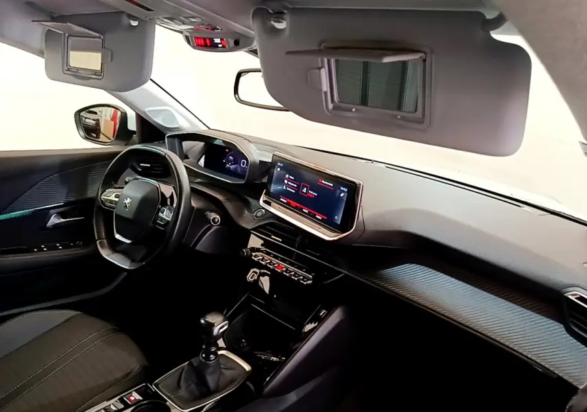 Intérieur noir du Peugeot 208 PureTech 100 S&S Allure Business 2020, vue côté conducteur avec tableau de bord et écran tactile.