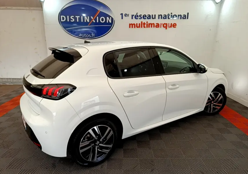 Peugeot 208 blanc vue 3/4 arrière côté droit, avec feux arrière LED et jantes alliage distinctives.