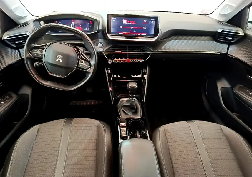 Intérieur Peugeot 208 PureTech 100 vue de face, tableau de bord avec écran tactile et volant cuir noir.