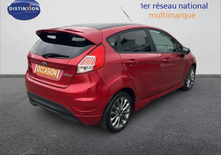 Vue 3/4 arrière droite d'une Ford Fiesta rouge 2017 avec jantes alliage et vitres surteintées.