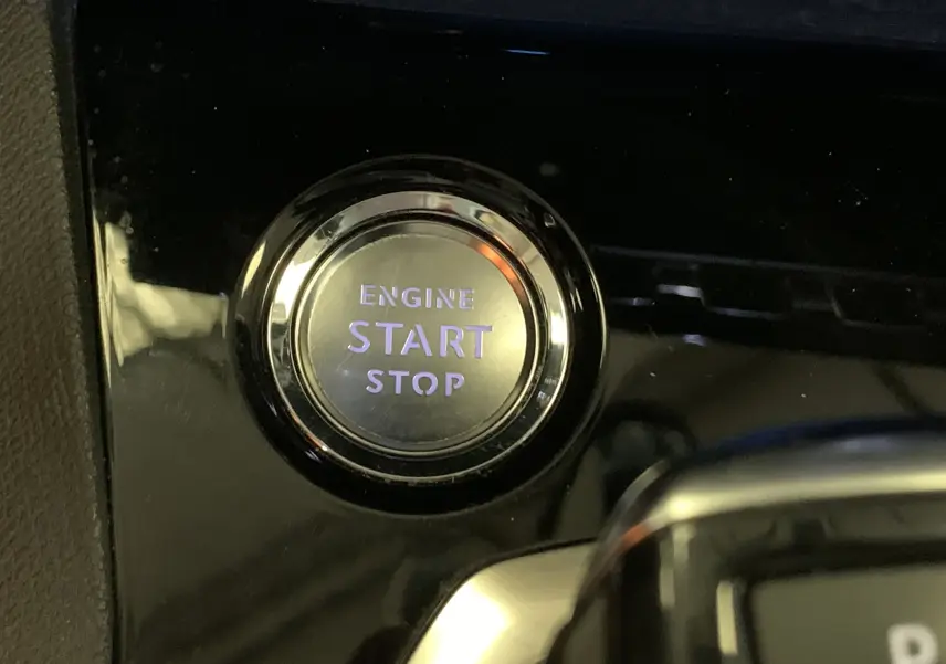 Gros plan sur la console centrale noire brillante du Peugeot 3008 PureTech 130 Allure Pack EAT8, levier de vitesse automatique et bouton Drive Mode.