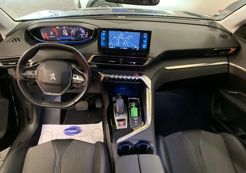 Gros plan sur la console arrière noire du Peugeot 3008 PureTech 130 Allure Pack avec prises USB et prise 12V.