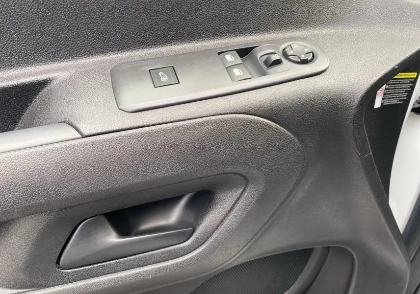 Gros plan sur la porte côté conducteur blanche du Citroën Berlingo 2019 avec commandes électriques et poignée noire.