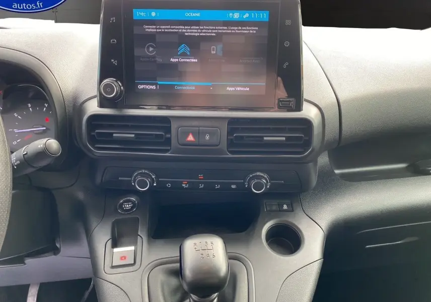 Vue intérieure du tableau de bord du Citroën Berlingo blanc 2019, avec écran tactile et levier de vitesses manuel.