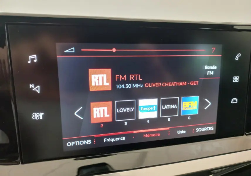 Écran tactile central affichant la radio FM RTL dans l’habitacle d’une Peugeot 208 blanche de 2021.