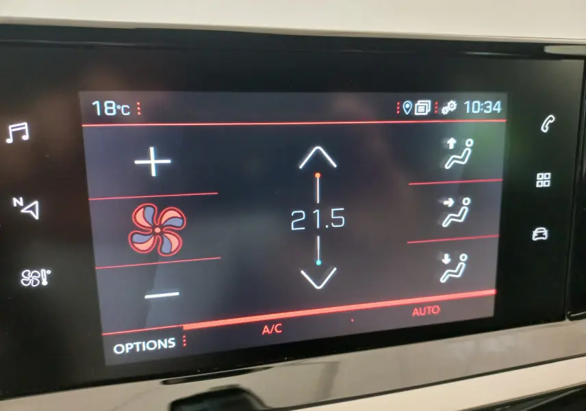 Écran tactile du système de climatisation affichant 21,5°C dans une Peugeot 208 blanche, vue intérieure rapprochée.