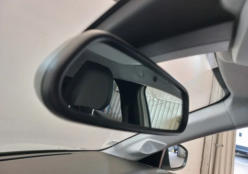 Rétroviseur intérieur de la Peugeot 208 PureTech 100 blanc, avec appui-tête et partie du tableau de bord visibles.