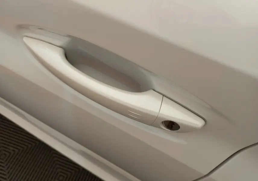 Poignée de porte blanche en gros plan sur le côté droit d'une Peugeot 208 PureTech 100 S&S Allure 2021.