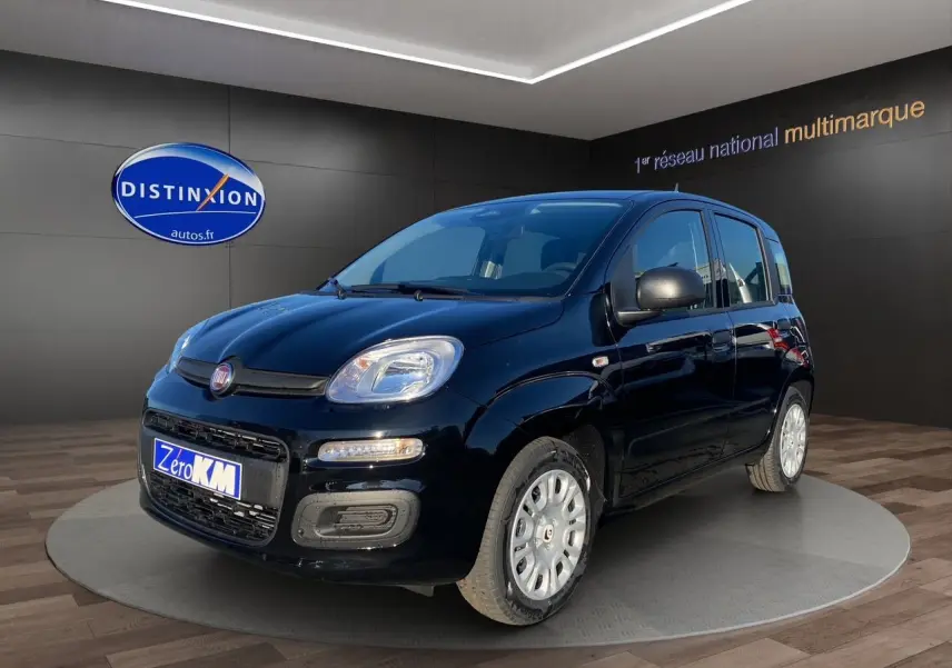 Vue 3/4 avant droite de la Fiat Panda noire 2025 avec jantes acier et feux LED, en showroom.