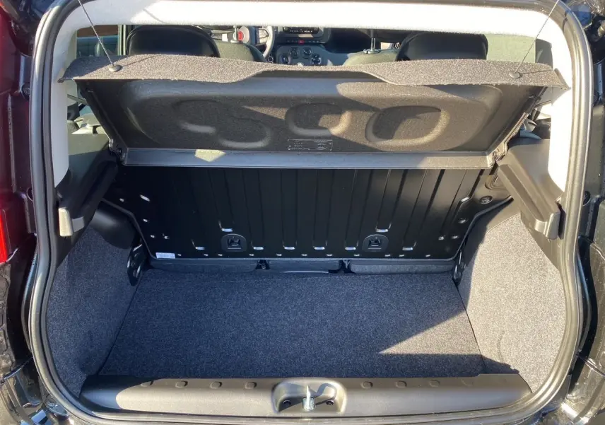 Coffre ouvert vu de l'arrière d'une FIAT Panda noire 2025, montrant l'espace de chargement et l'intérieur arrière.