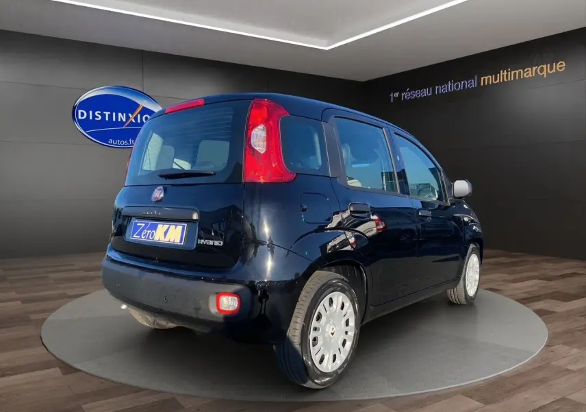 Vue 3/4 arrière droite d'une FIAT Panda noire 2025 avec hayon et feux arrière verticaux dans un showroom.